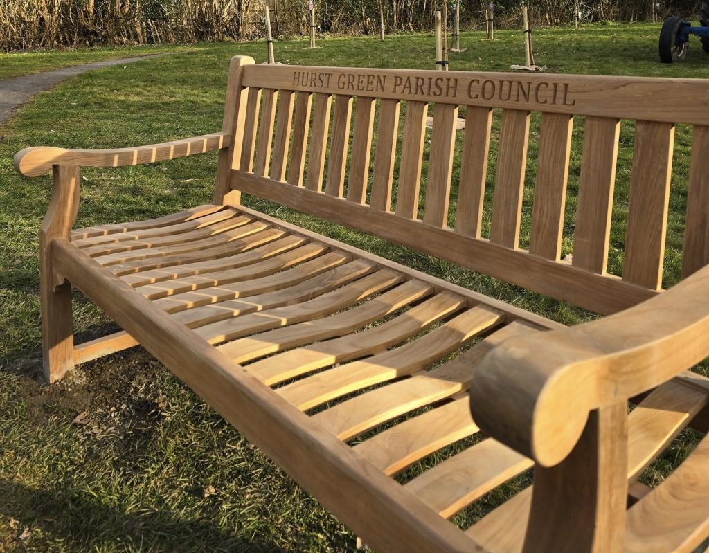 photograph of a new park bench in front of newly planted orchard